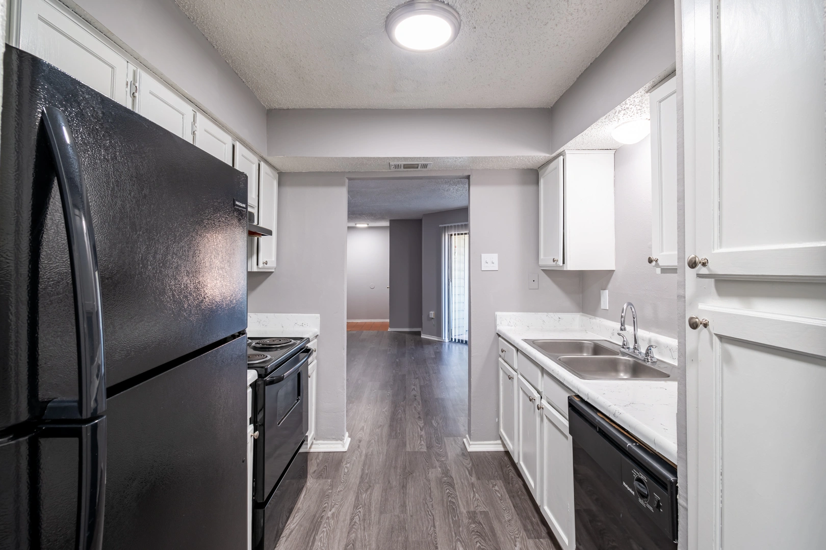 Kitchen entry and refrigerator at La Prada Place Apartment Homes
