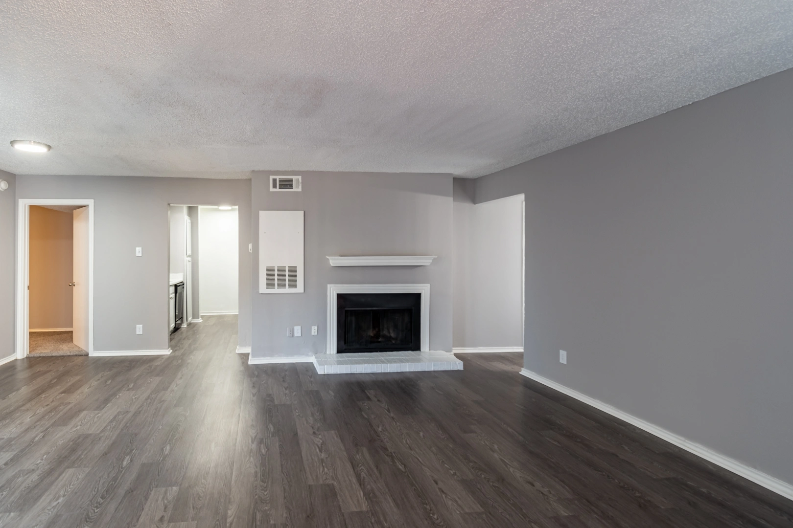 Wood-style living room and fireplace at La Prada Place Apartment Homes