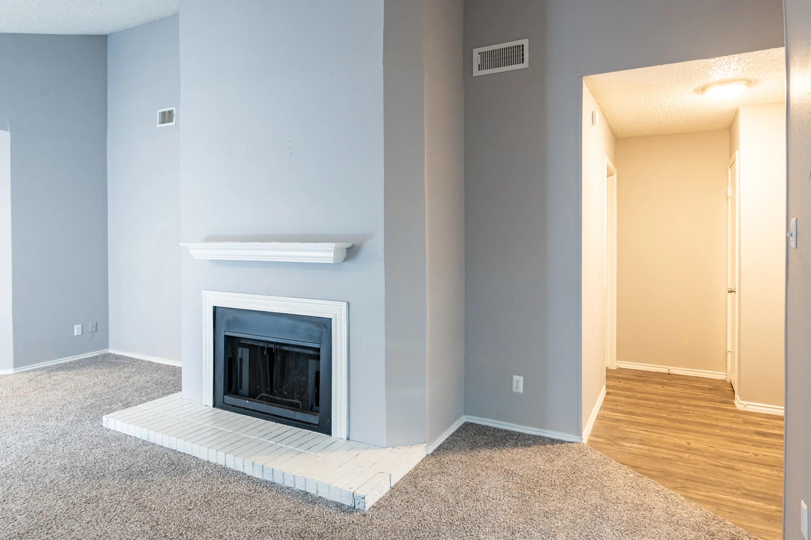Living room center fireplace at La Prada Place Apartment Homes