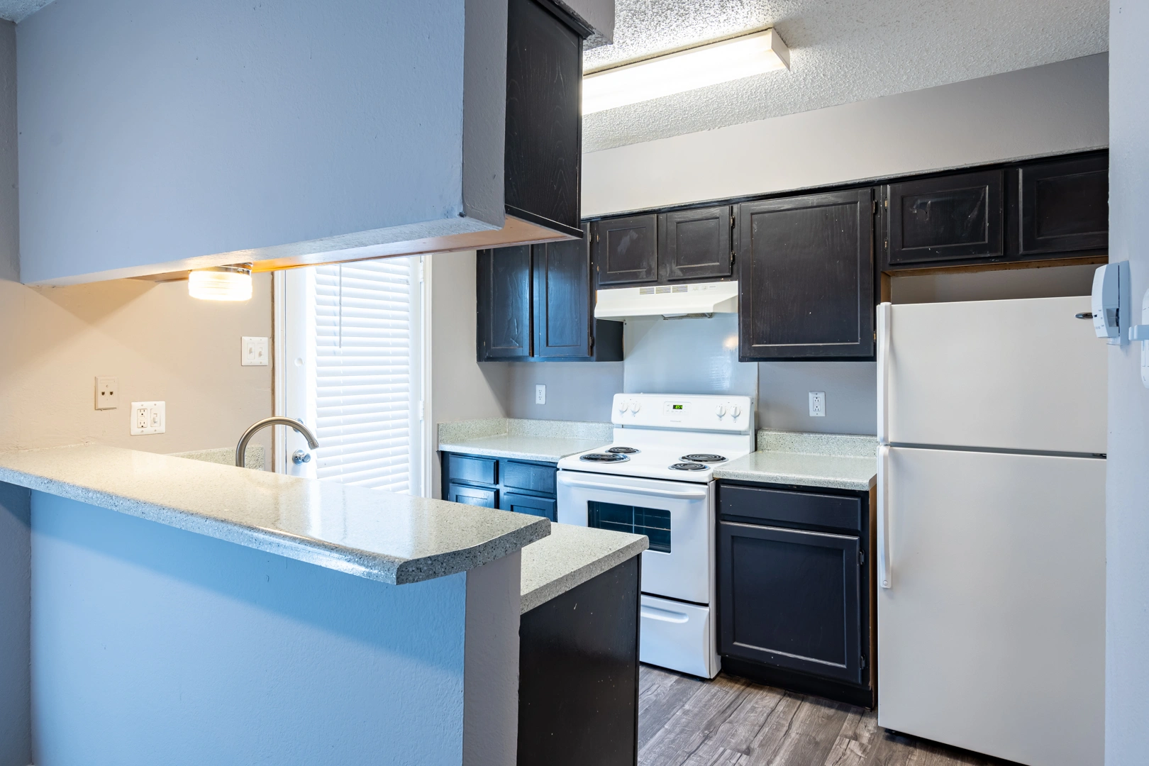 Kitchen breakfast bar and cabinets at La Prada Place Apartment Homes