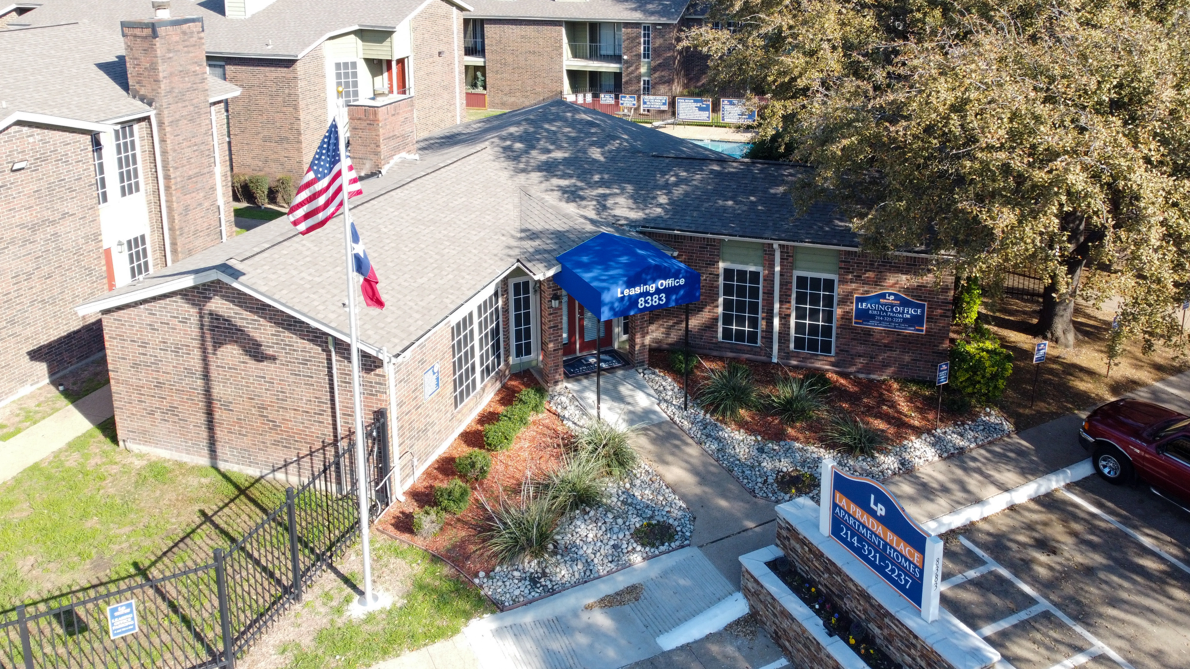 Gated entrance and flags at La Prada Place Apartment Homes