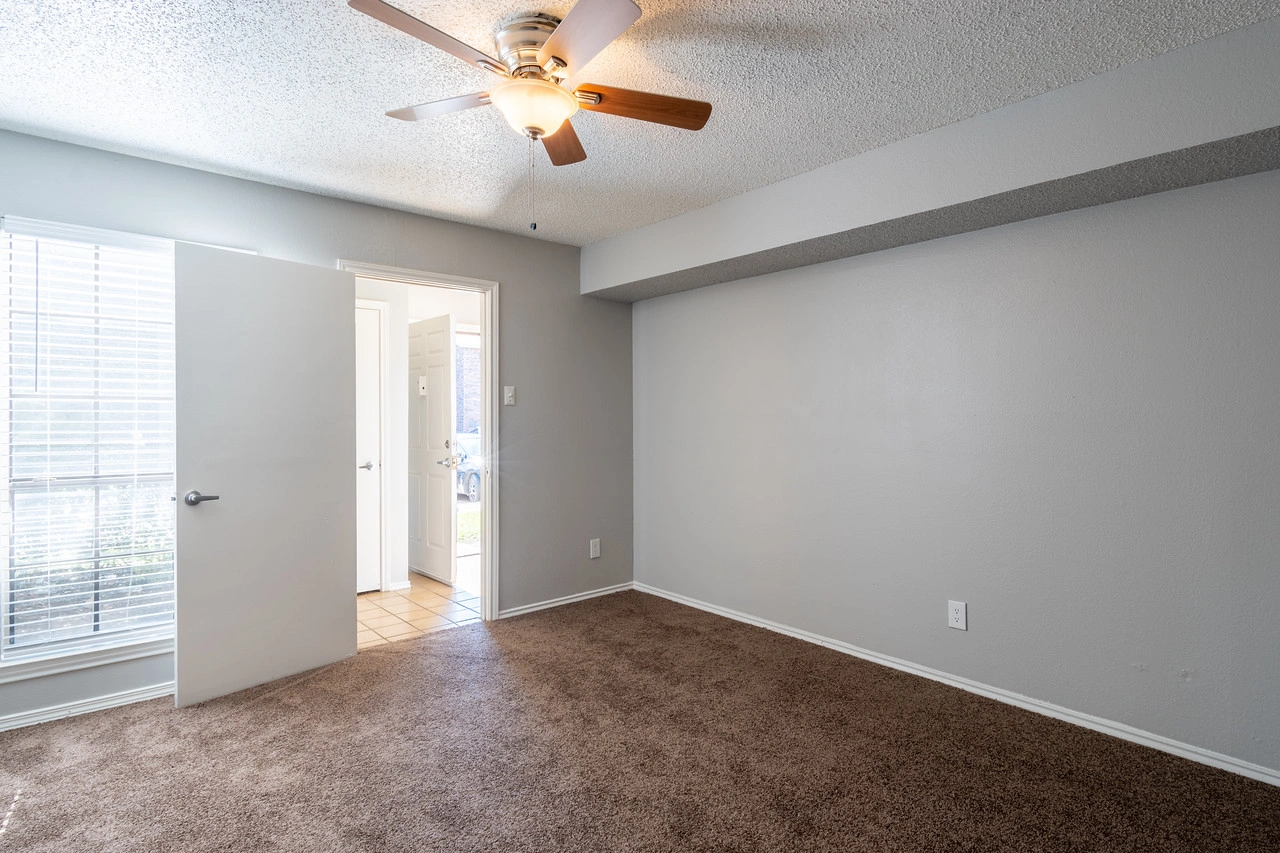 Primary bedroom with ceiling fan at La Prada Place Apartment Homes